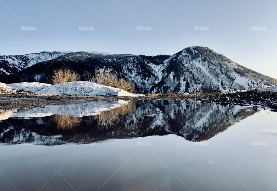 reflection of mountains in a puddle