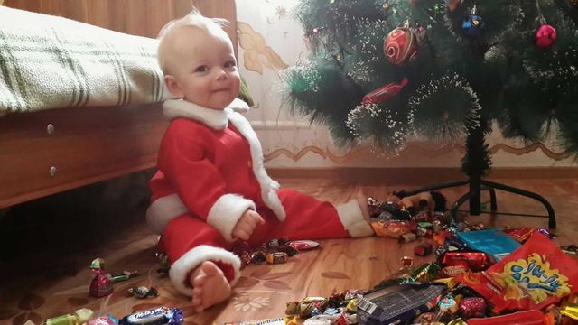 Boy wearing santa costume playing with chocolates