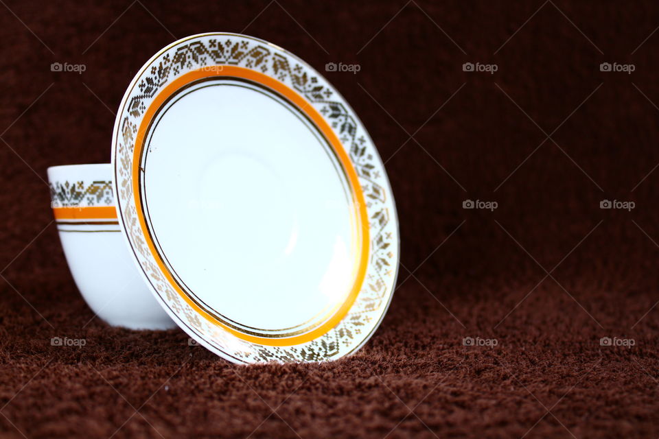 Porcelain tea cup and saucer on carpet
