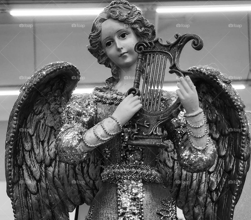 black and white filtered angel with a harp statue under flourescent lights in an Oregon thrift store