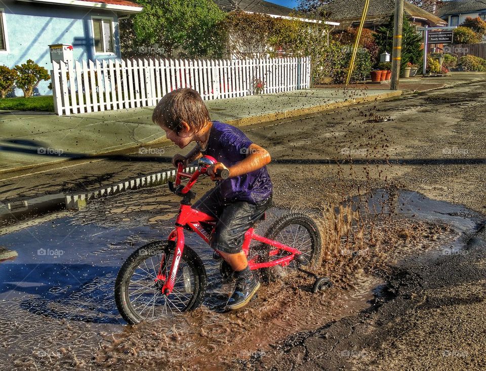 Boy getting muddy and messy on his bike