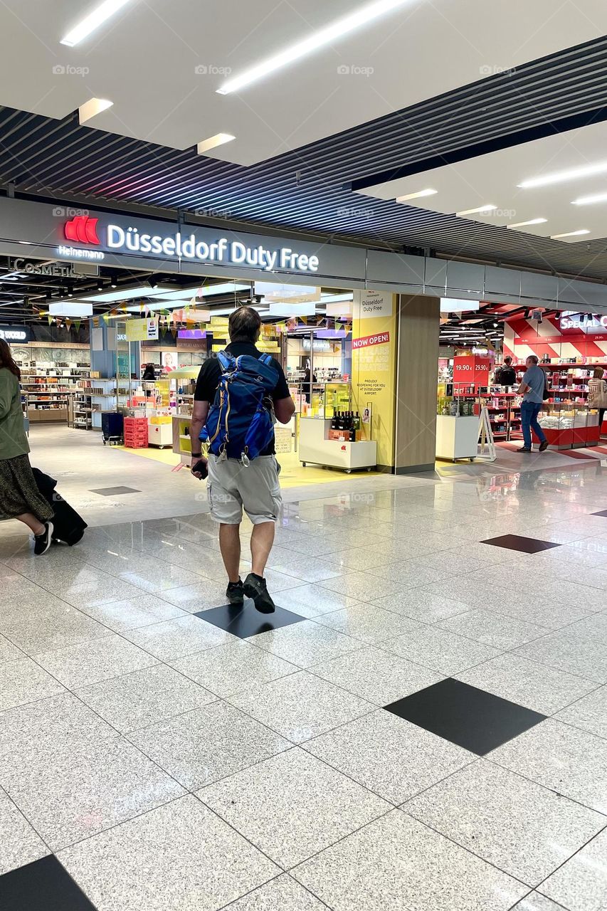 Man walking towards the duty free store in the airport 