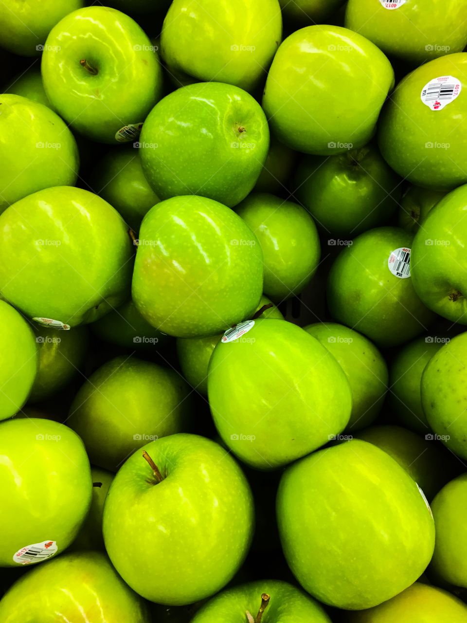 Green Granny Smith apples in the produce section 