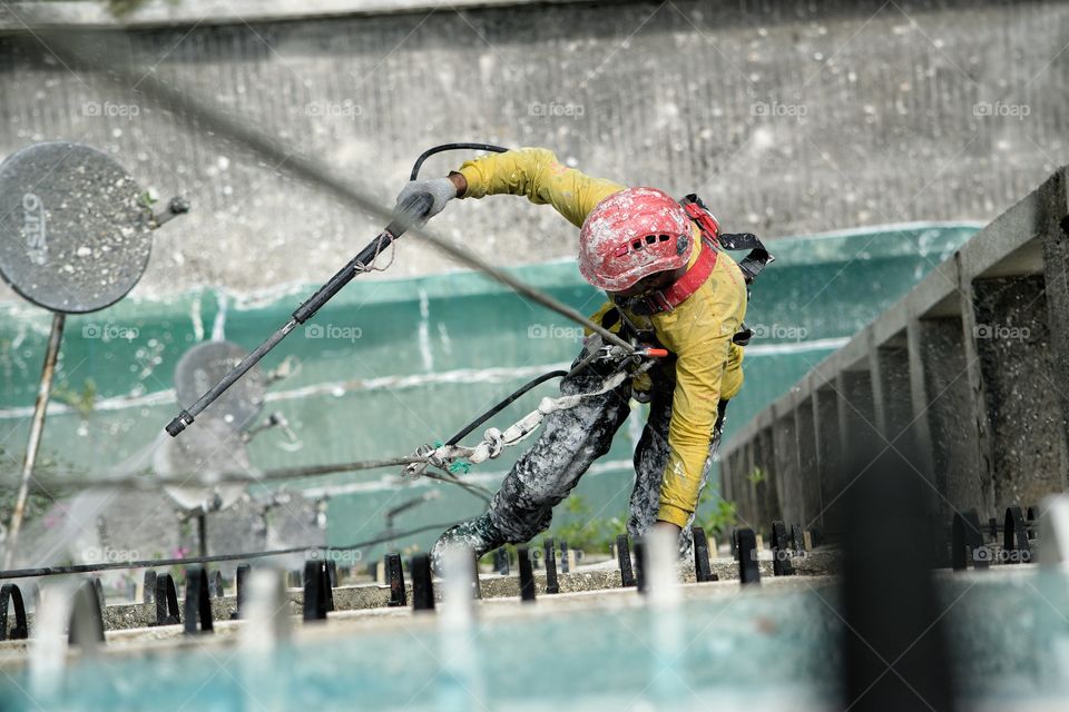 Worker abseiling Dow side of tower block in Kuala Lumpur Malaysia