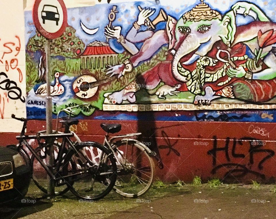 Great streetscape with graffiti and mural photographed at night in the Jardin, Amsterdam, Netherlands 