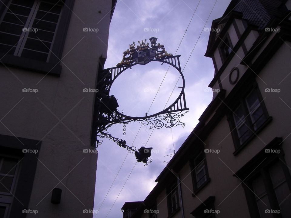 A round empty sign between two houses against the sky