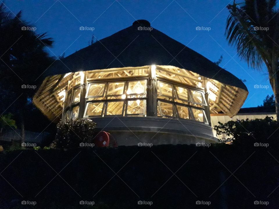 A bright giant hut illuminating at Night Time in the Hotel front.