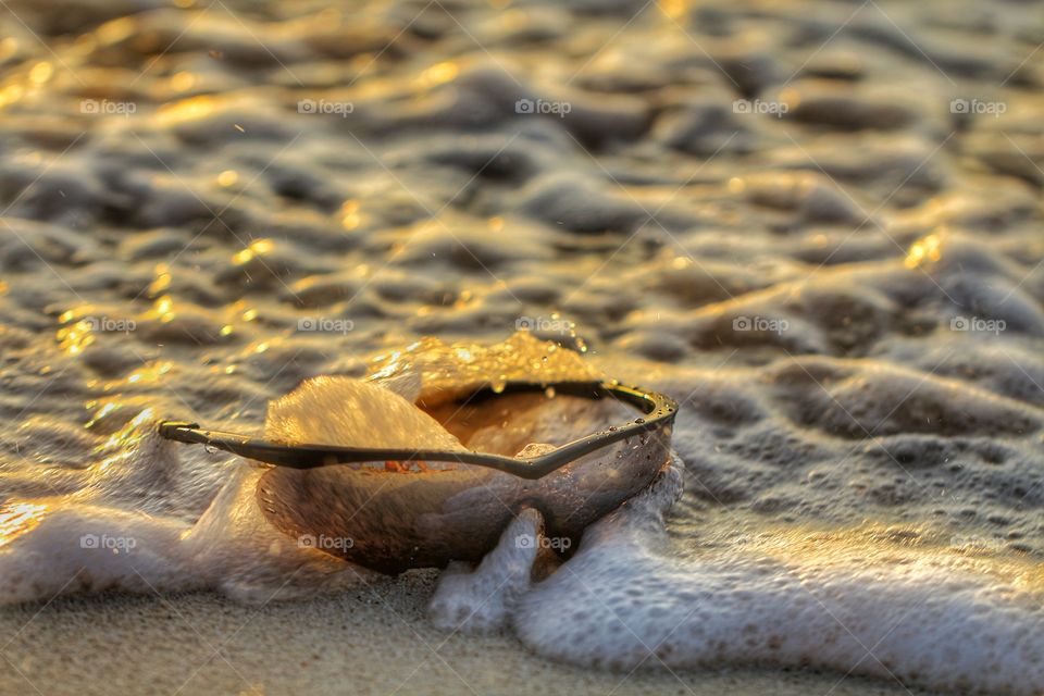 Sunglasses hit by the waves