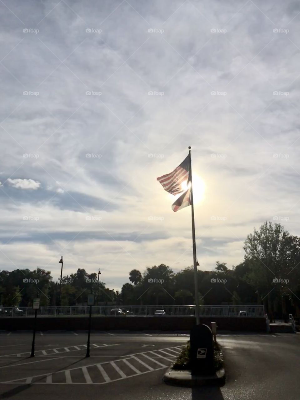 Sun setting behind American and Florida flags 