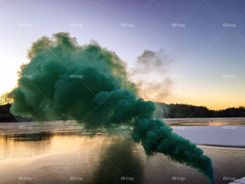 Green smoke against idyllic lake
