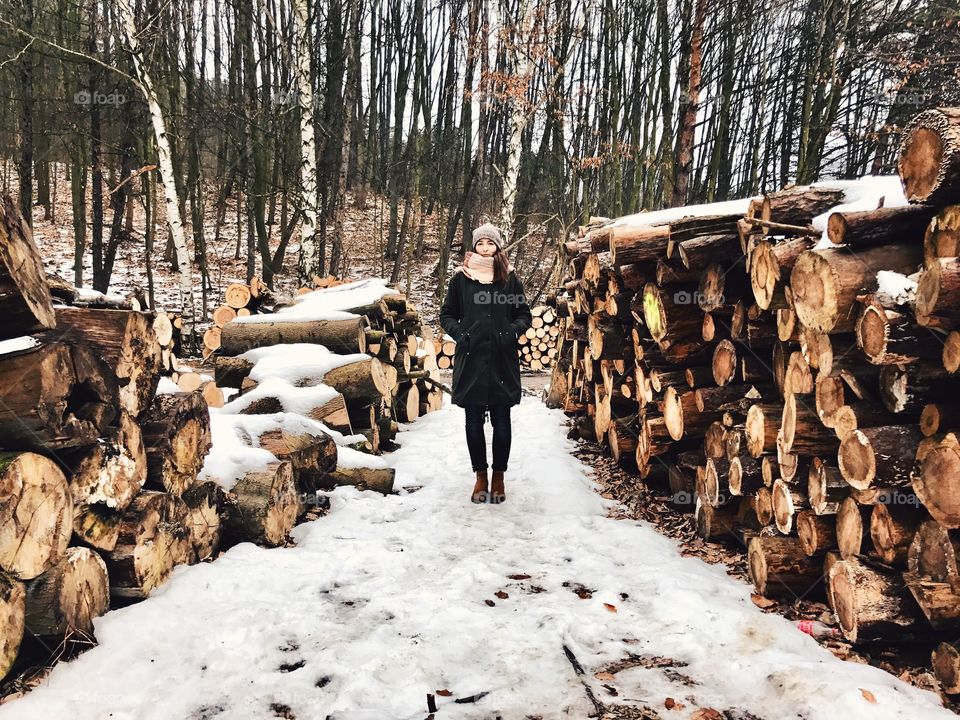 Woman standing in between firewood