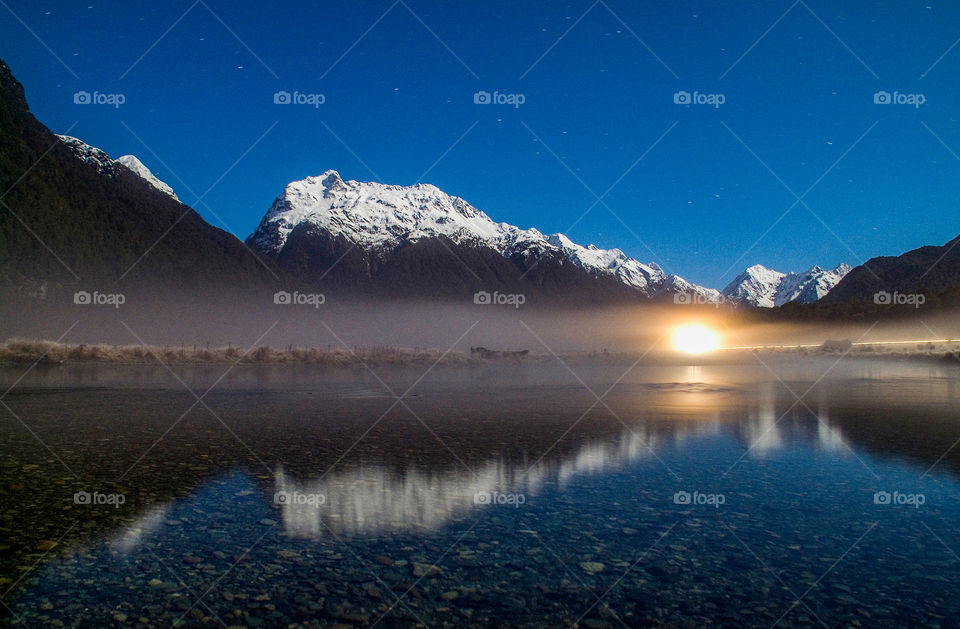 Snowy mountain and sky reflecting on lake
