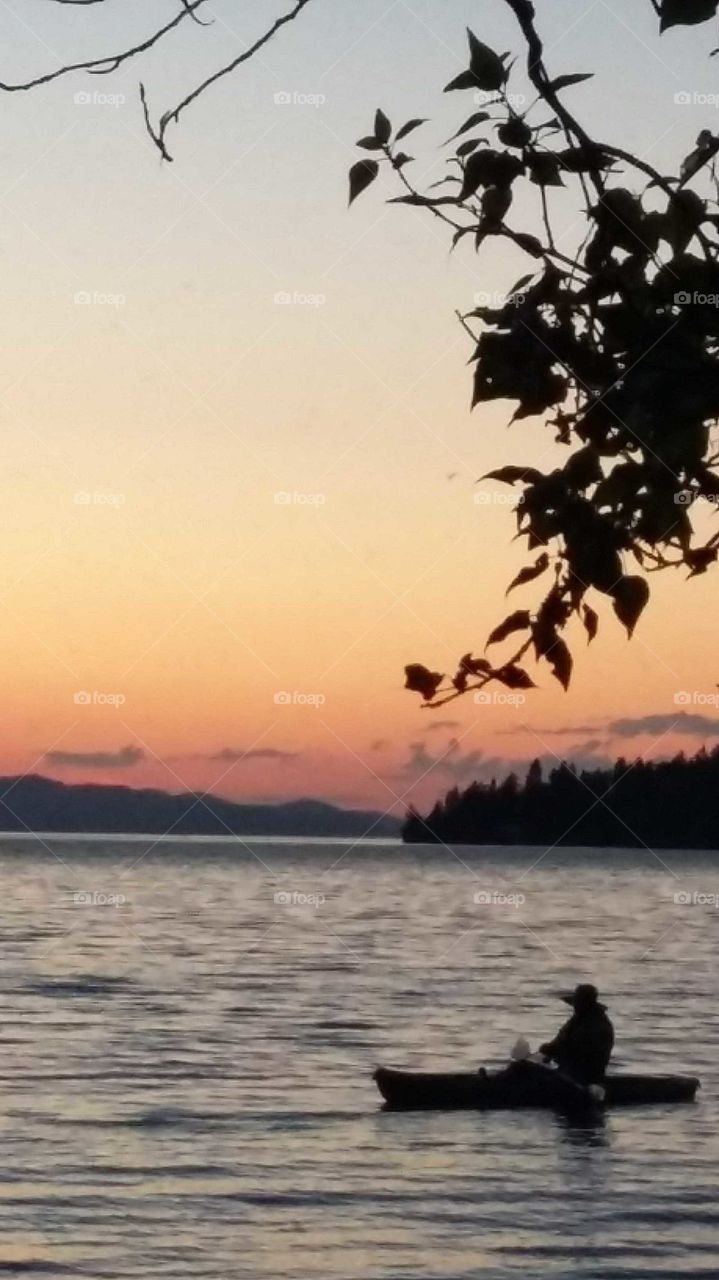Glorious sunset withsilhouette of tranquil fisherman on Flathead Lake Montana