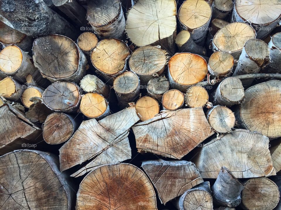 Pile of cut firewoods of different shapes and colours