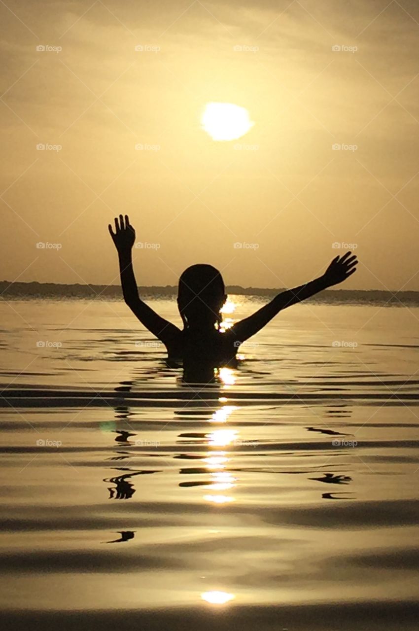 Little girl silhouette sunset beach 