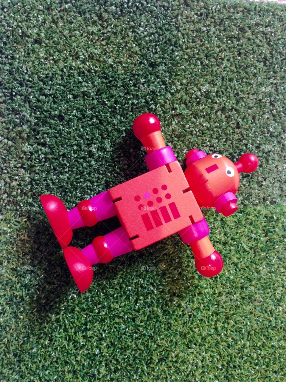 Red toy robot on grass 