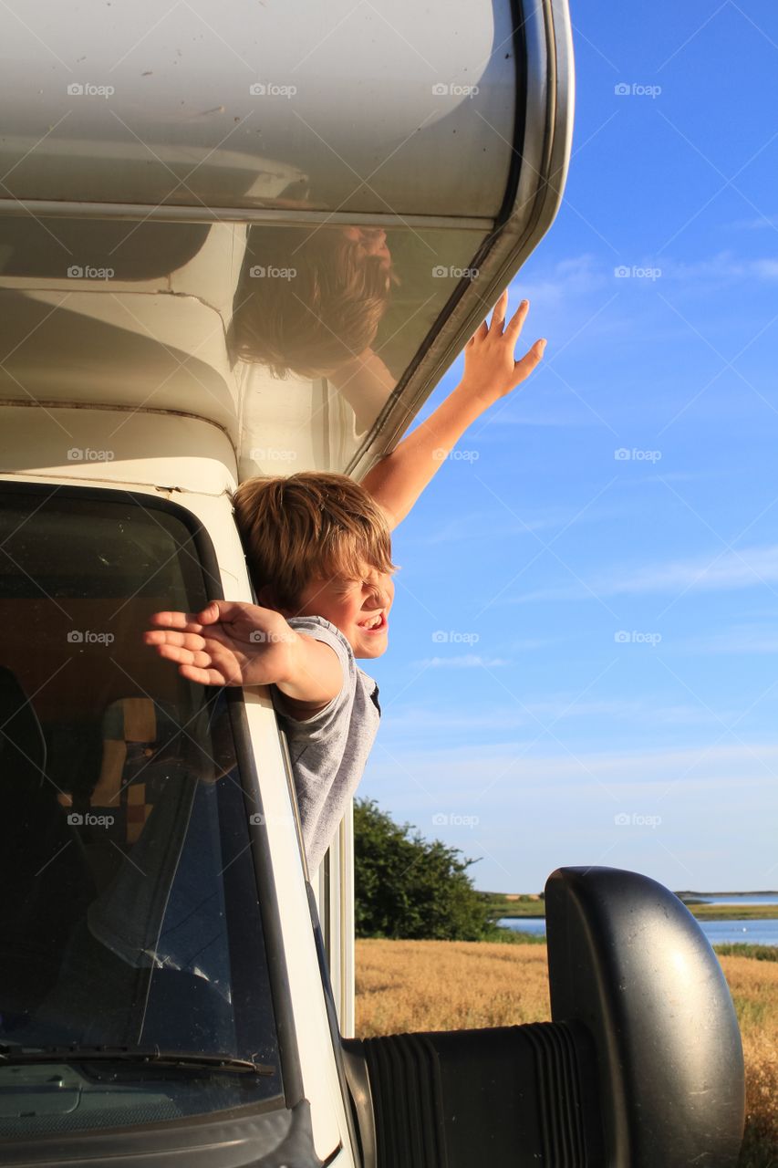 Child leaning out of a motorhome window 