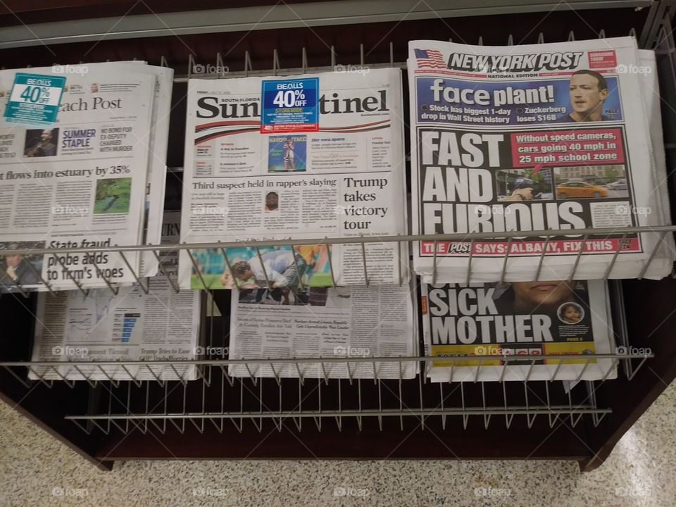 The Palm Beach Post is seen amidst the Sun-Sentinel and New York Post on a newsstand in West Palm Beach, Florida, United States.