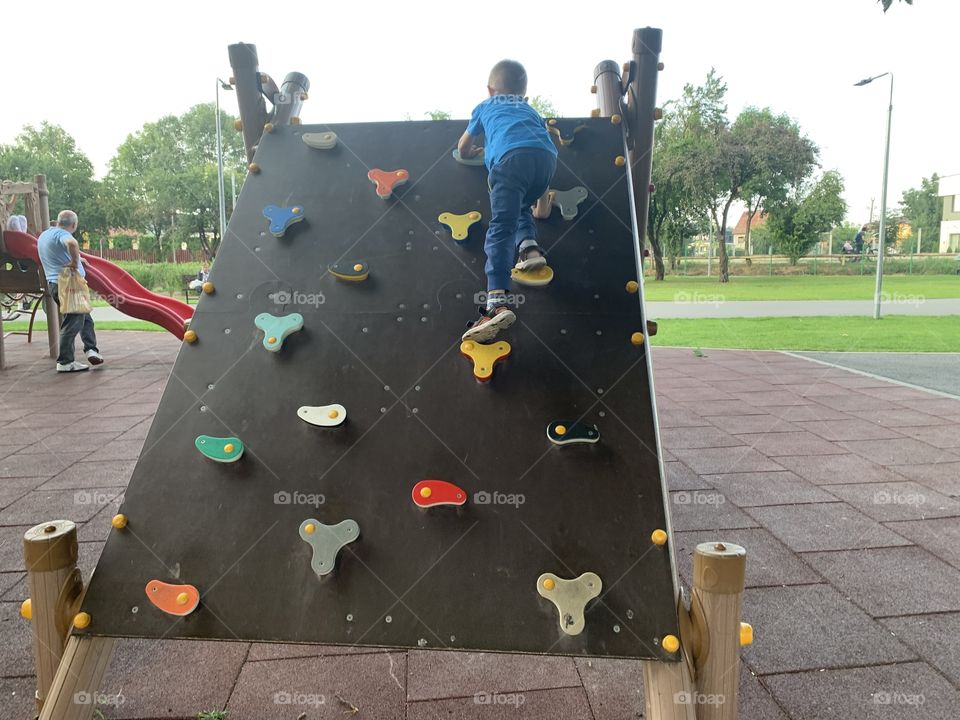 Cool Child on climbing frame at the park, strong legs 