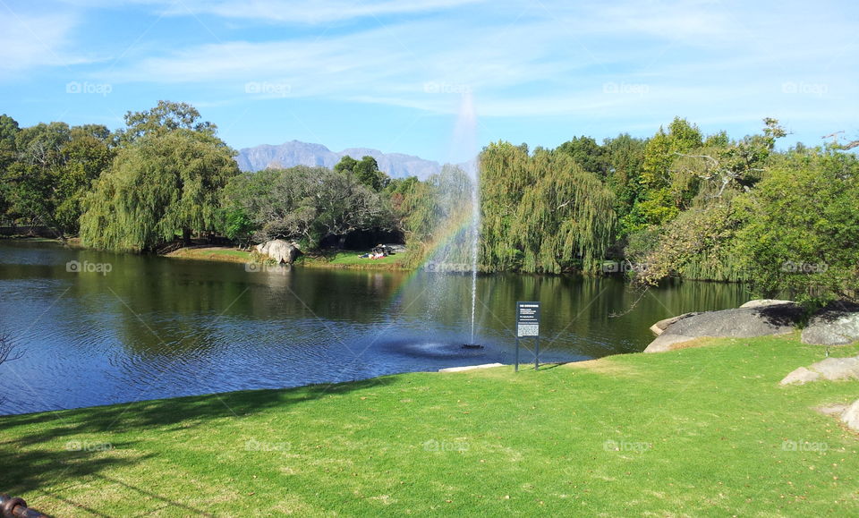 The dam with a rainbow in the fountain at Spier a winery hotel and conference centre near Stellenbosch South Africa