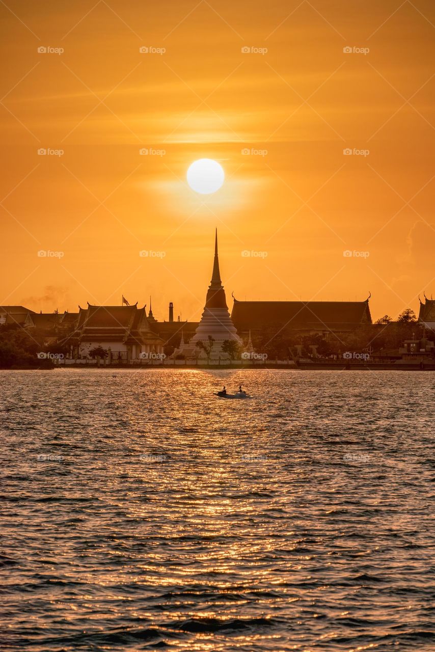 Golden sunset scene above Thai pagoda