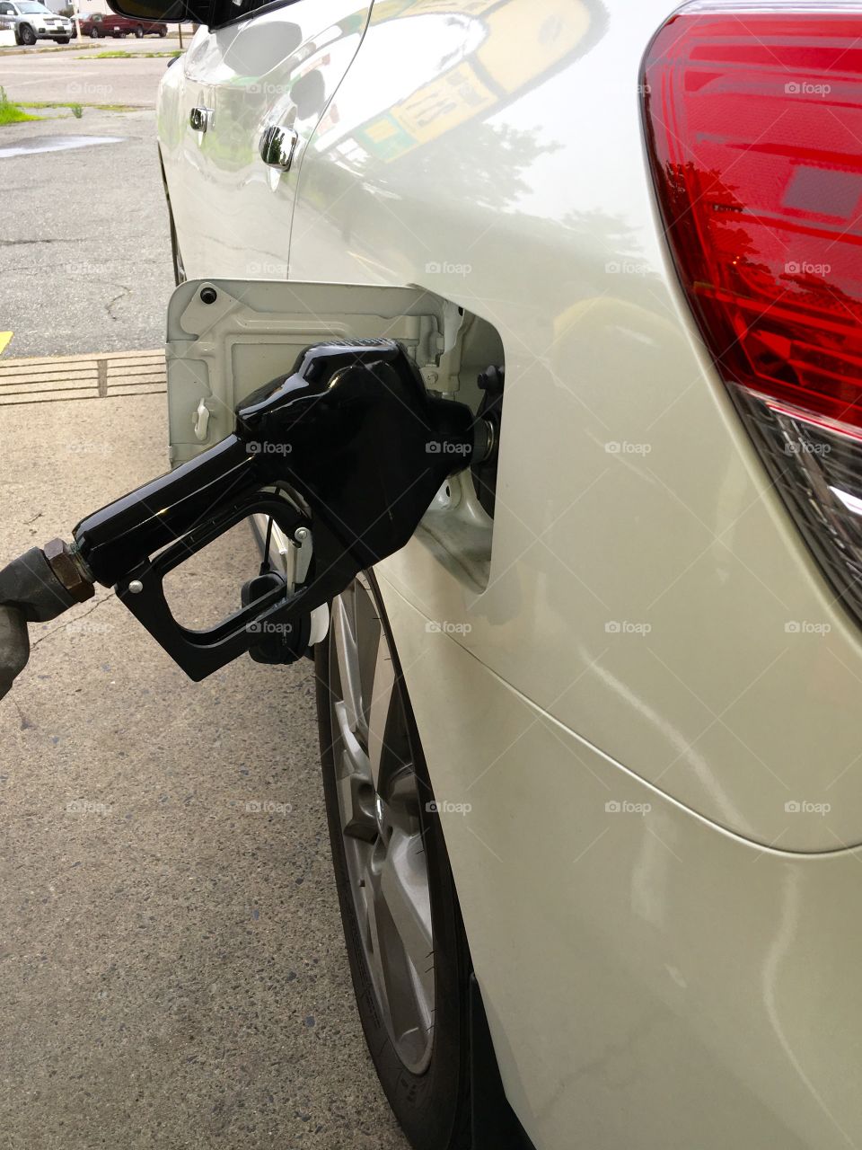 Pumping gas into car gas tank. Set to pump itself!