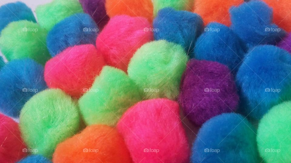 Multi colored fuzzy balls that can be used for many different art projects. There are pink, red, green, blue, orange, and purple balls.