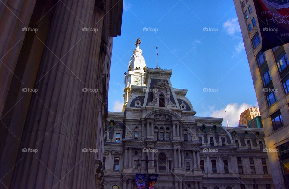 Philadelphia City Hall Entrance Gate and Clock Tower Between Down Town Buildings at Sunrise on Blue Sky Day