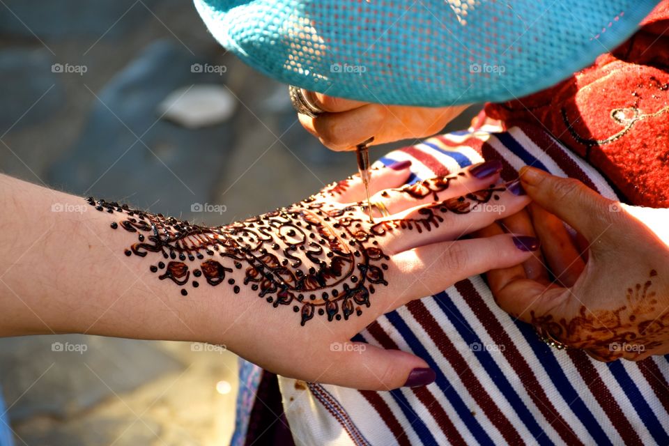 Woman paiting hand with henna, Morroco