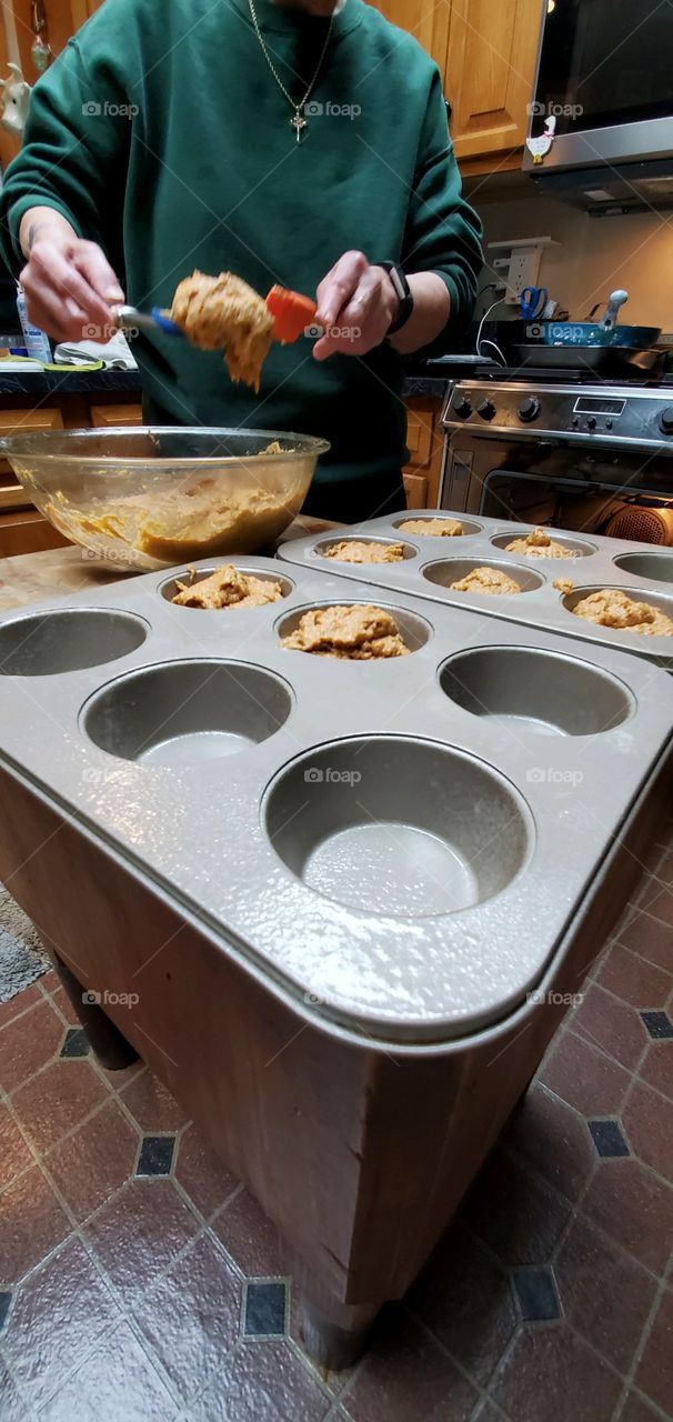 Baking homemade sweet potato muffins, now filling pans with batter.
