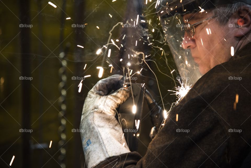 This welder is building a frame by welding bar steel together using fixtures to produce a ROPS frame for a heavy equipment Cab. 
