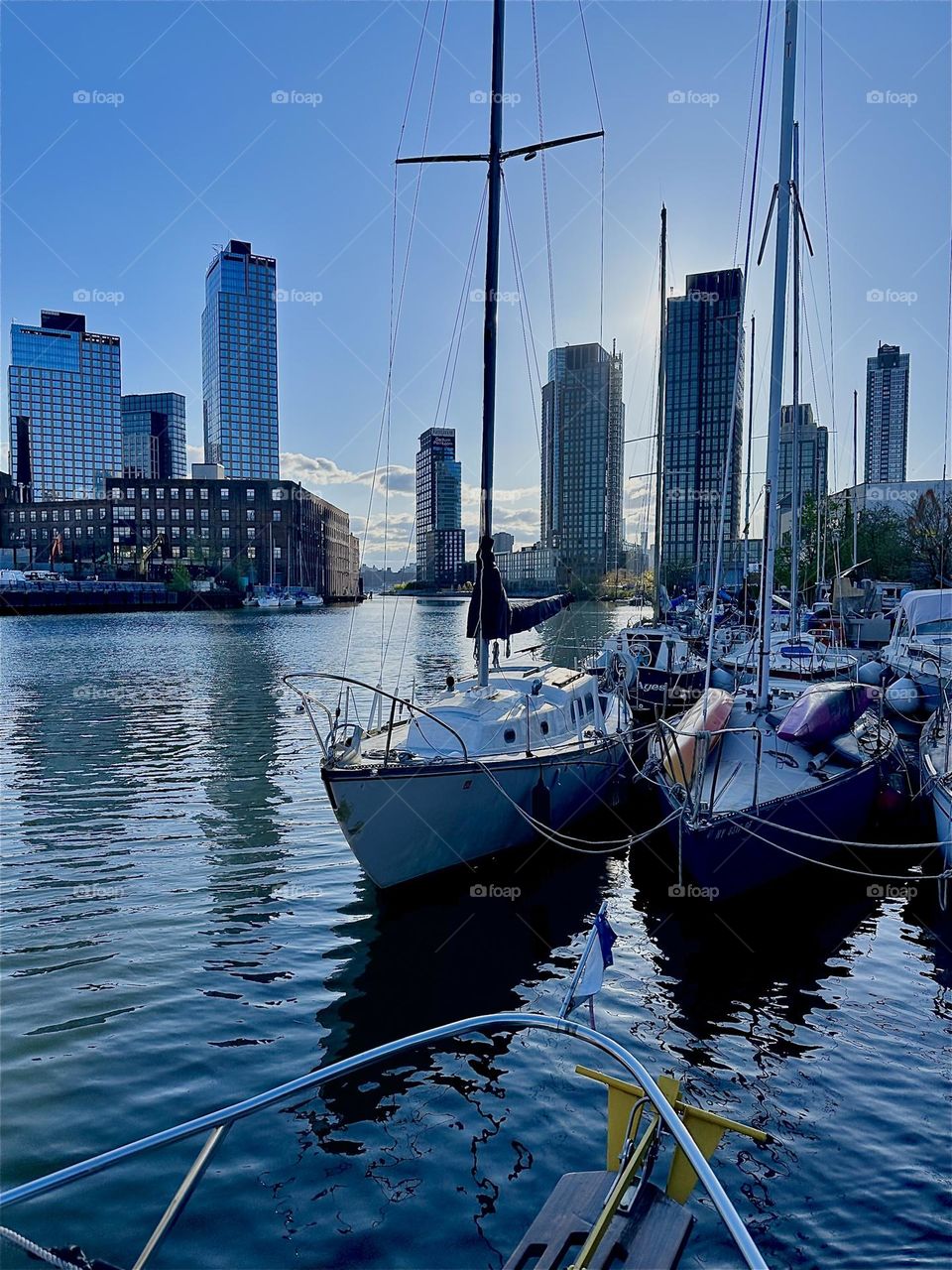 This is „Newtown Creek“ by the „Pulaski Bridge“ in LIC, Queens with its many boats. The water of the „East River“ shimmers gently in shades of silver blue at twilight time just before nightfall. 2024. Hypnotic Productions