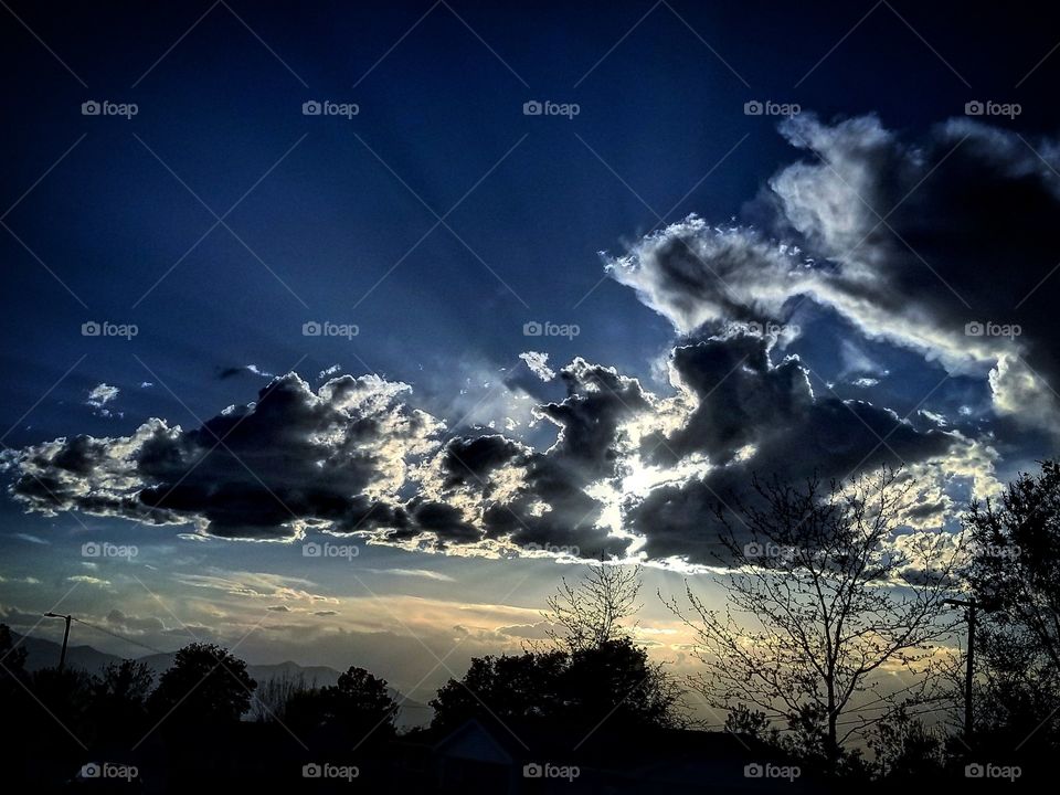 hello friends when we look up towards the sky you will see the sunrise stretching out through the amazing deep blue up above to say hello. Beautiful blue sky clouds and the sun giving light through the clouds and sky.