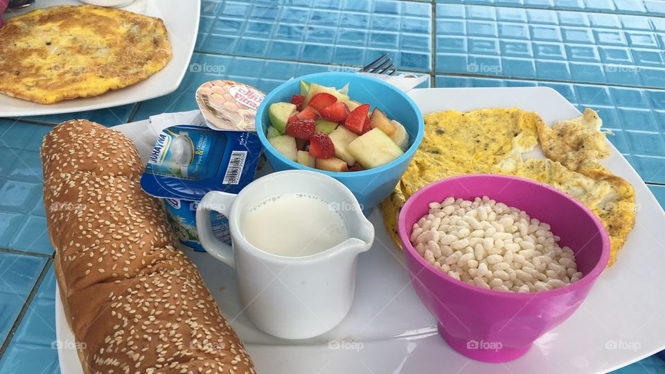 Healthy breakfast with eggs and fruits in colorful plates