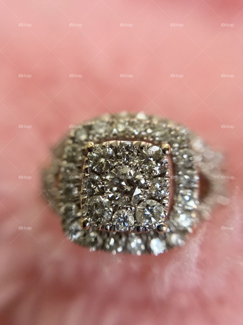 Diamond engagement ring on pink fluffy background