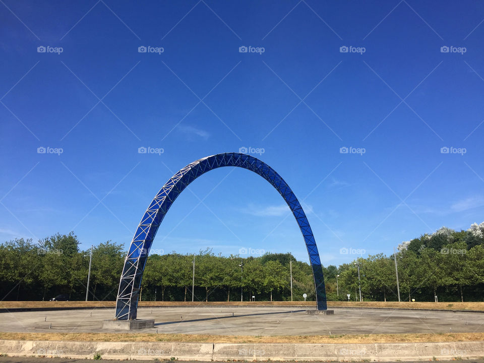 Big blue metal arch in the middle of the road