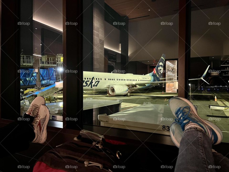 Man and woman feet on the airplane background in the airport 