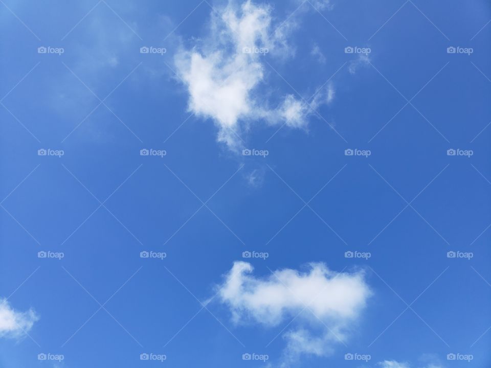 blue sky with small fluffy clouds