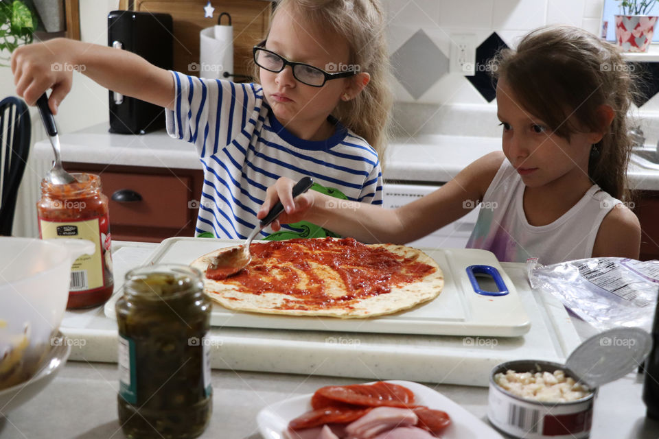 Siblings making pizza