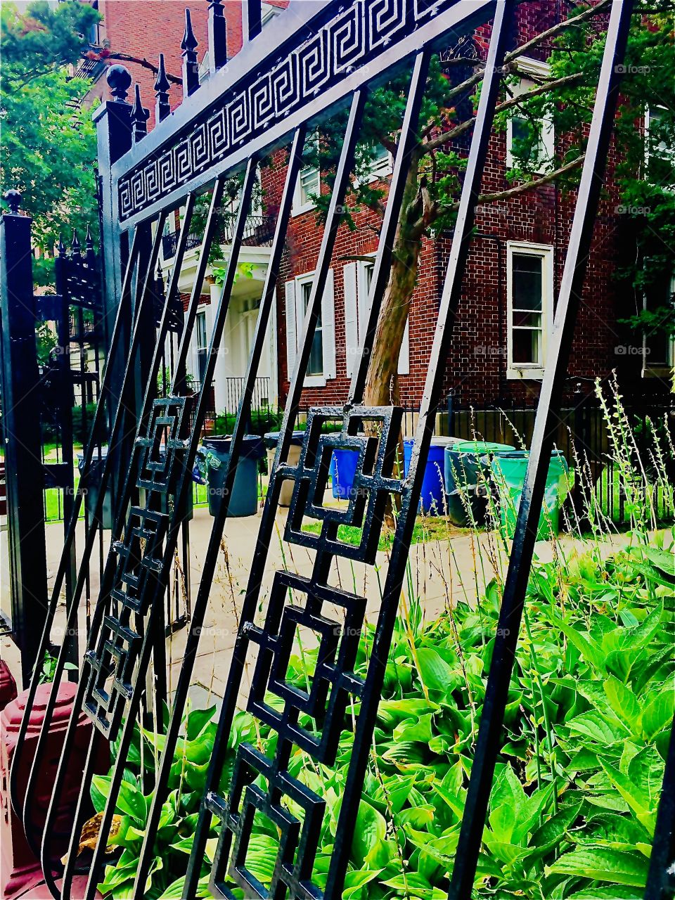 An interesting detail of one of the many brownstones in Fort Greene, Brooklyn is this unusually shaped iron cast fence bent inwards with ornamentation and gate. Photo from 2020. Hypnotic Productions