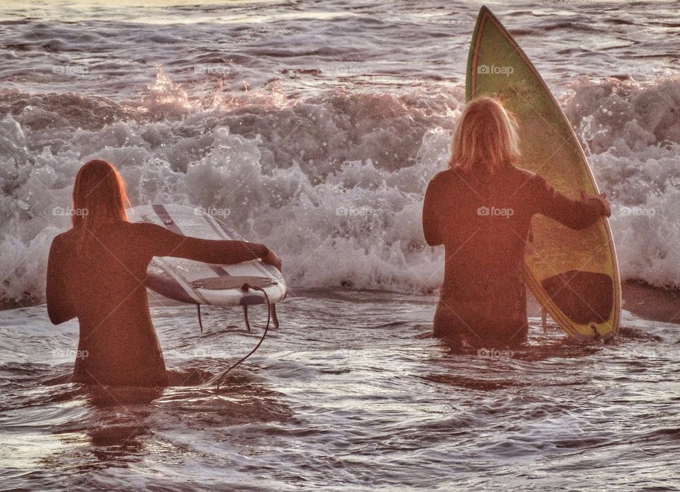 Man and woman entering the waves in Half Moon Bay, California
