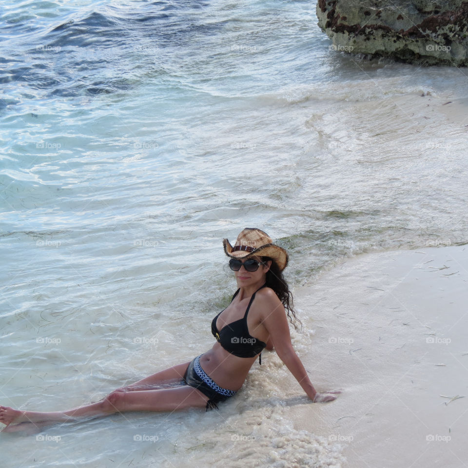Young woman in bikini sitting on the beach