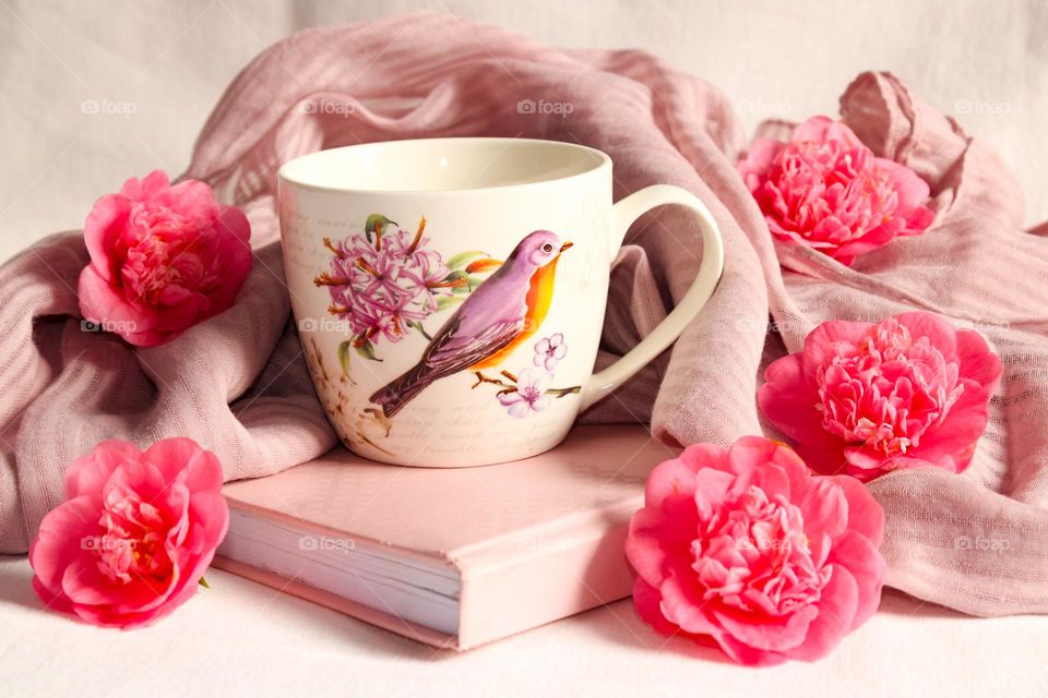 Pink mug, book and flowers