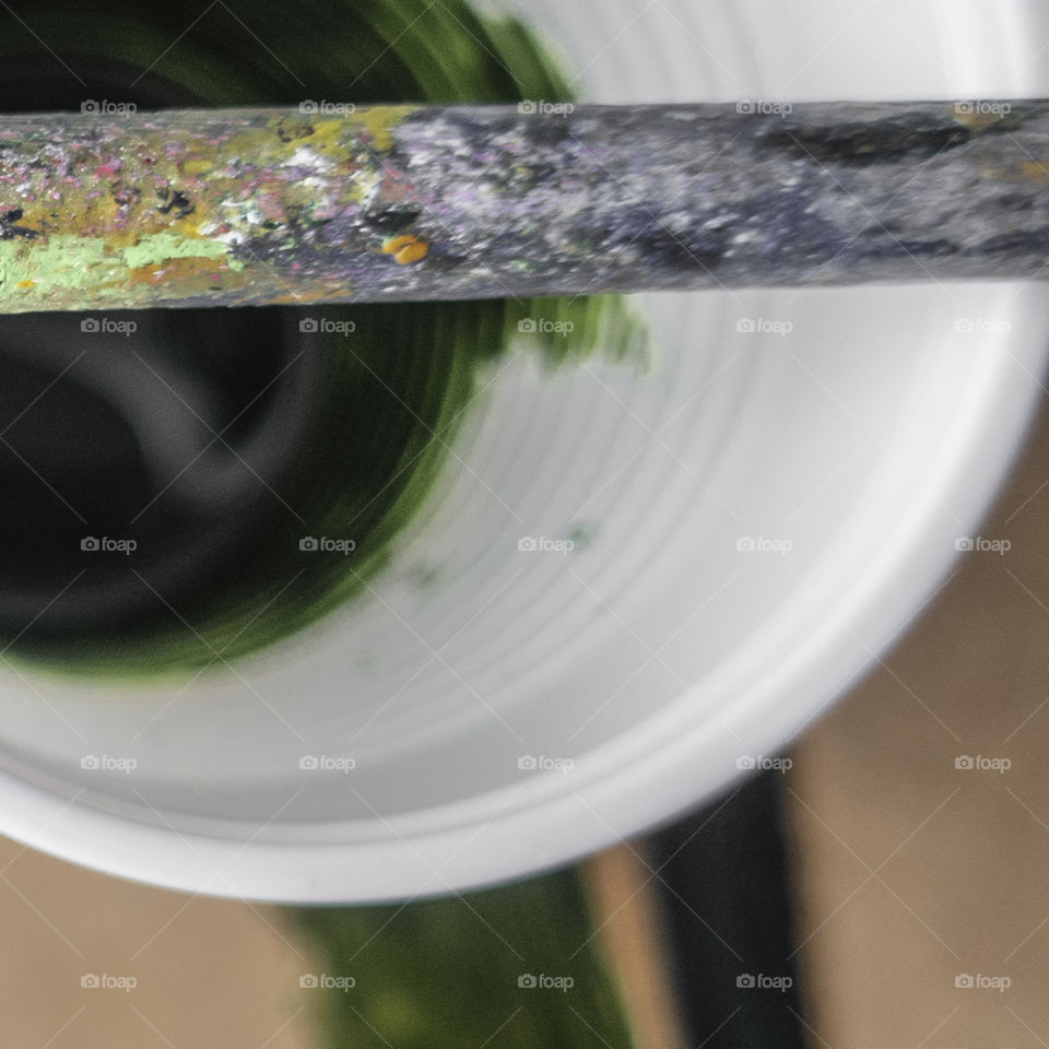 A cup with green color and a brush 