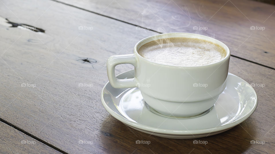 Hot coffee in white glass on wooden table