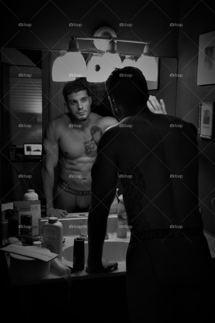 Reflection of shirtless man in mirror