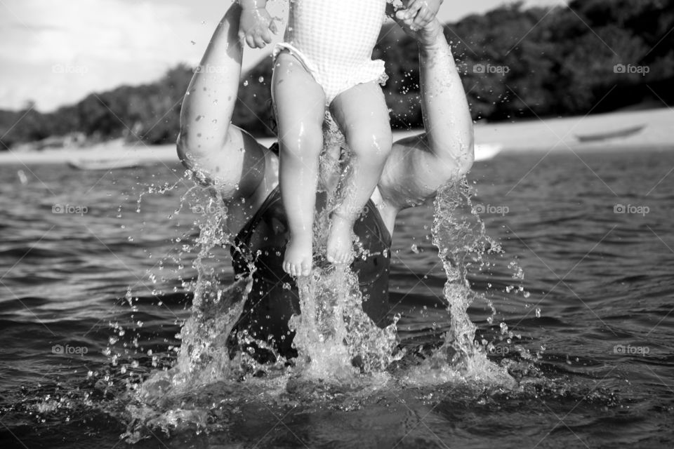mother saviour pulls baby out of the river water mother and daughter habing fun in the river ocean black and white