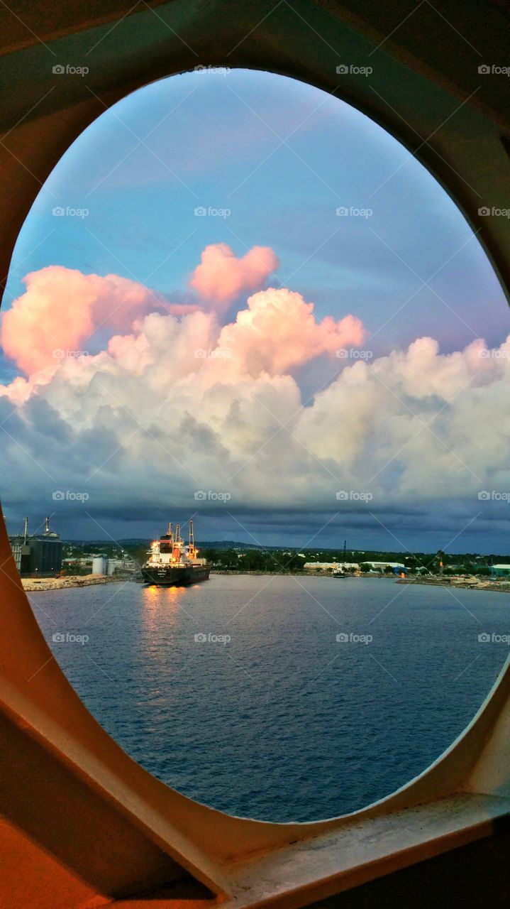 Tanker ship and sunset through Port hole Barbados