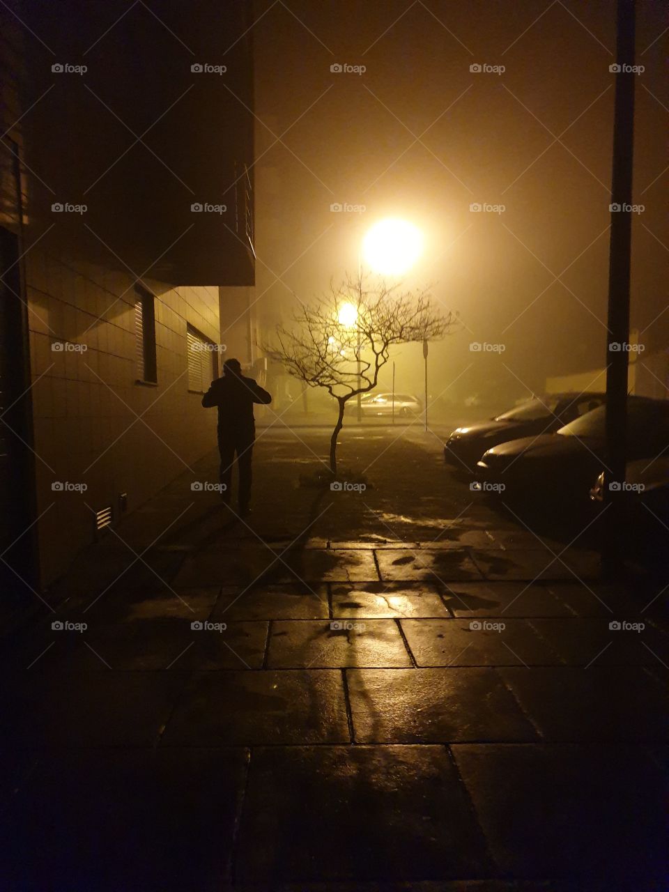 man walking at night during a foggy night