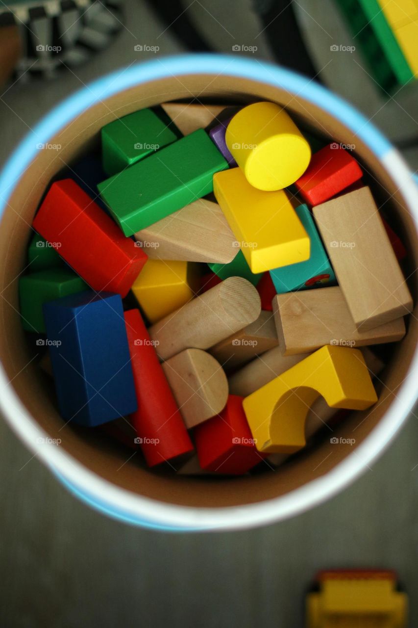 Close-up view from above of colorful children's building blocks in a round box